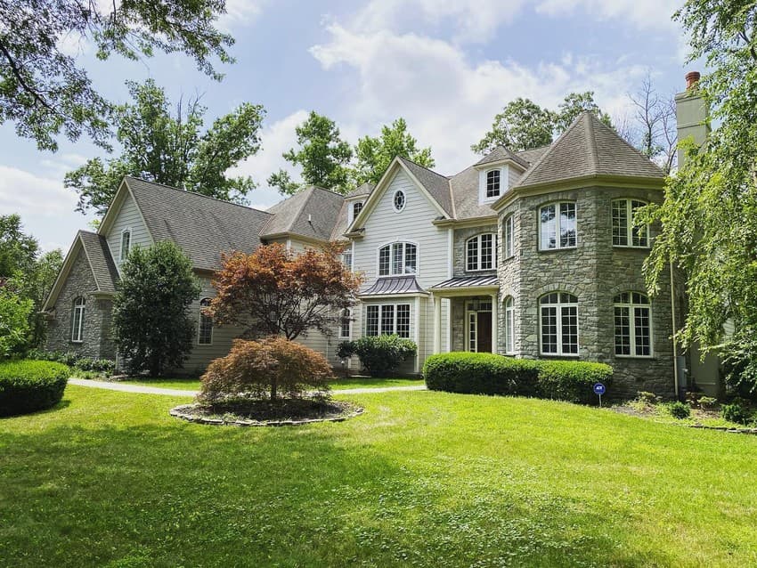 Tudor inspired home featuring Hardie plank lap siding in a custom color with stone accents and metal roof accent. Tudor inspired home featuring Hardie plank lap siding in a custom color with stone accents and metal roof accent.