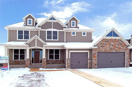 Prepare Your Home for Winter: CHECK AND REPAIR WALKWAYS AND DRIVEWAYS House covered in snow with a cleared sidewalk
