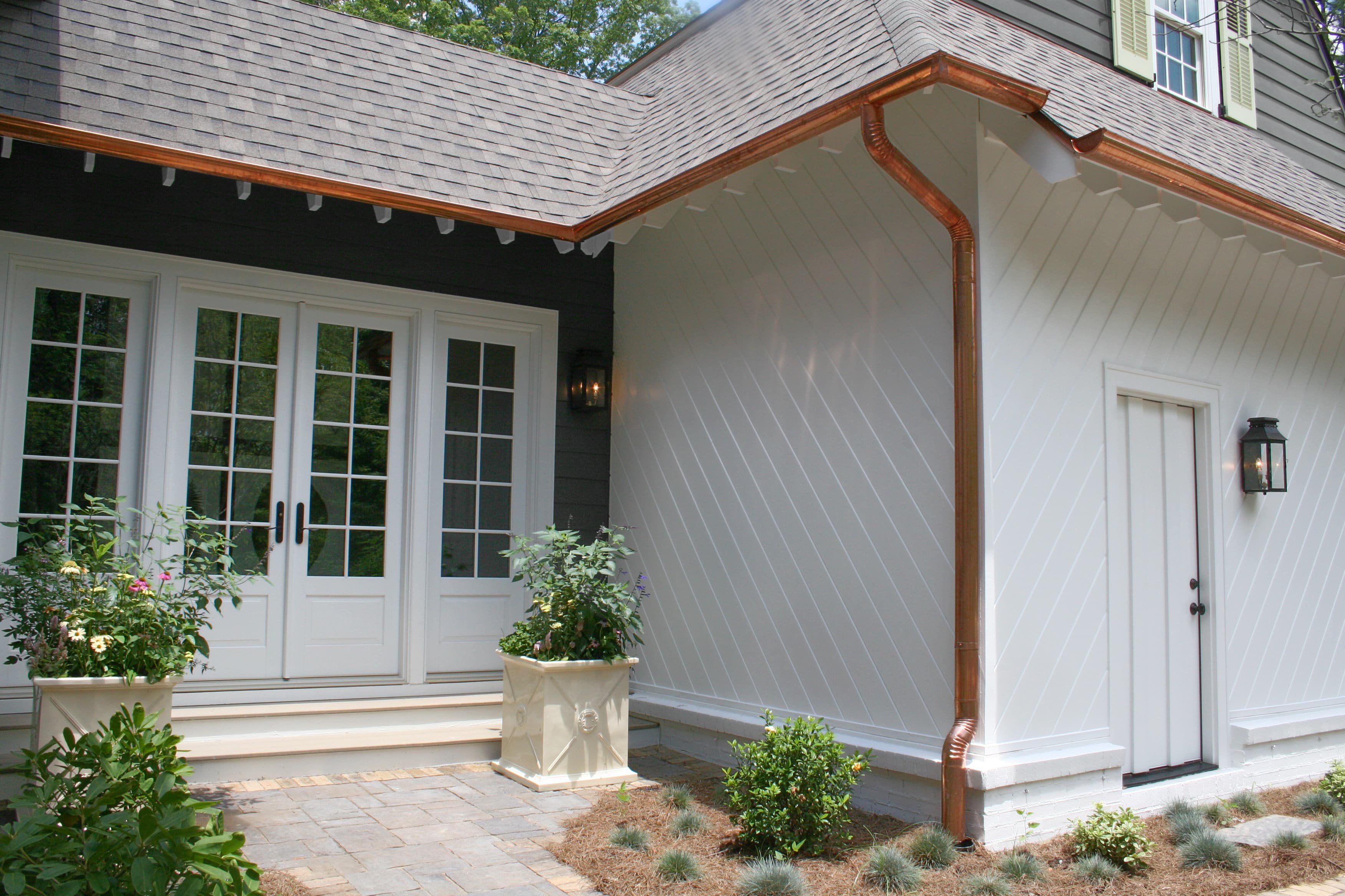 Enhancing Your Home's Exterior: Detail of a home clad in Arctic White and Iron Gray Hardie® Artisan® with bright copper rain gutters Detail of a home clad in Arctic White and Iron Gray Hardie® Artisan with bright copper rain gutters