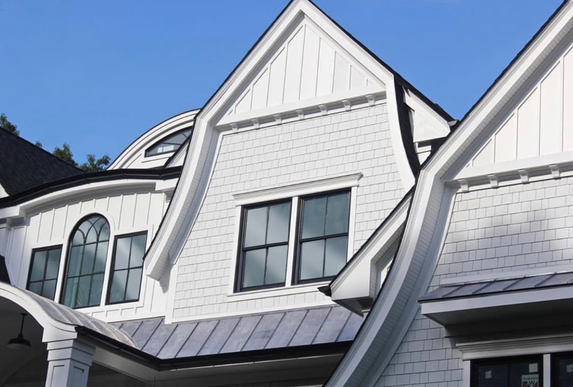 Dutch Colonial house clad in Hardie Panel Vertical Siding in a board and batten accent and Hardie Shingle Siding all in Arctic White Dutch Colonial house clad in Hardie Panel Vertical Siding in a board and batten accent and Hardie Shingle Siding all in Arctic White