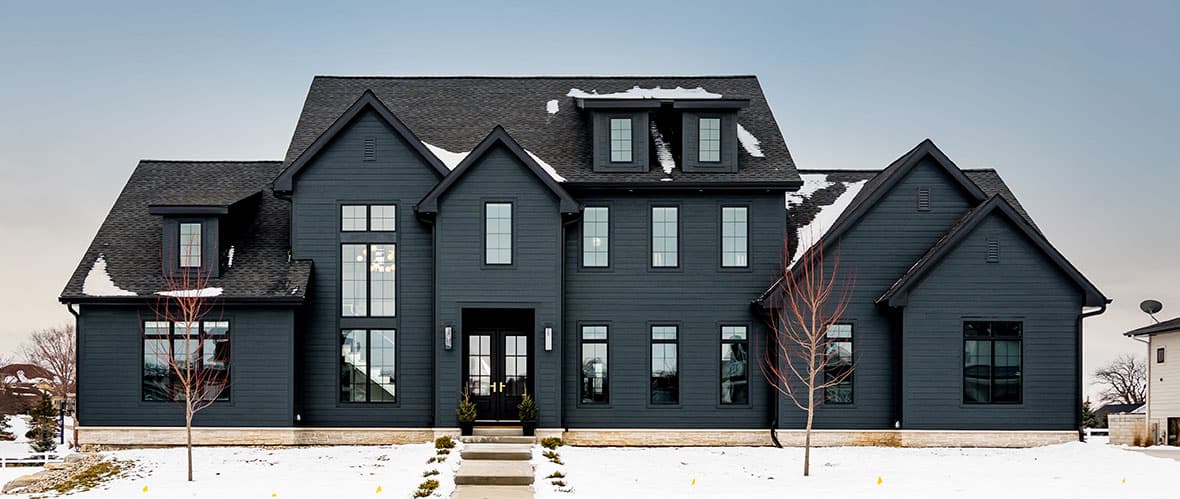 Custom home in Wisconsin featuring Hardie Plank Lap Siding in the Dream Collection finish Shou Sugi Ban. Builder is Acker Builders Inc. gray home with snow