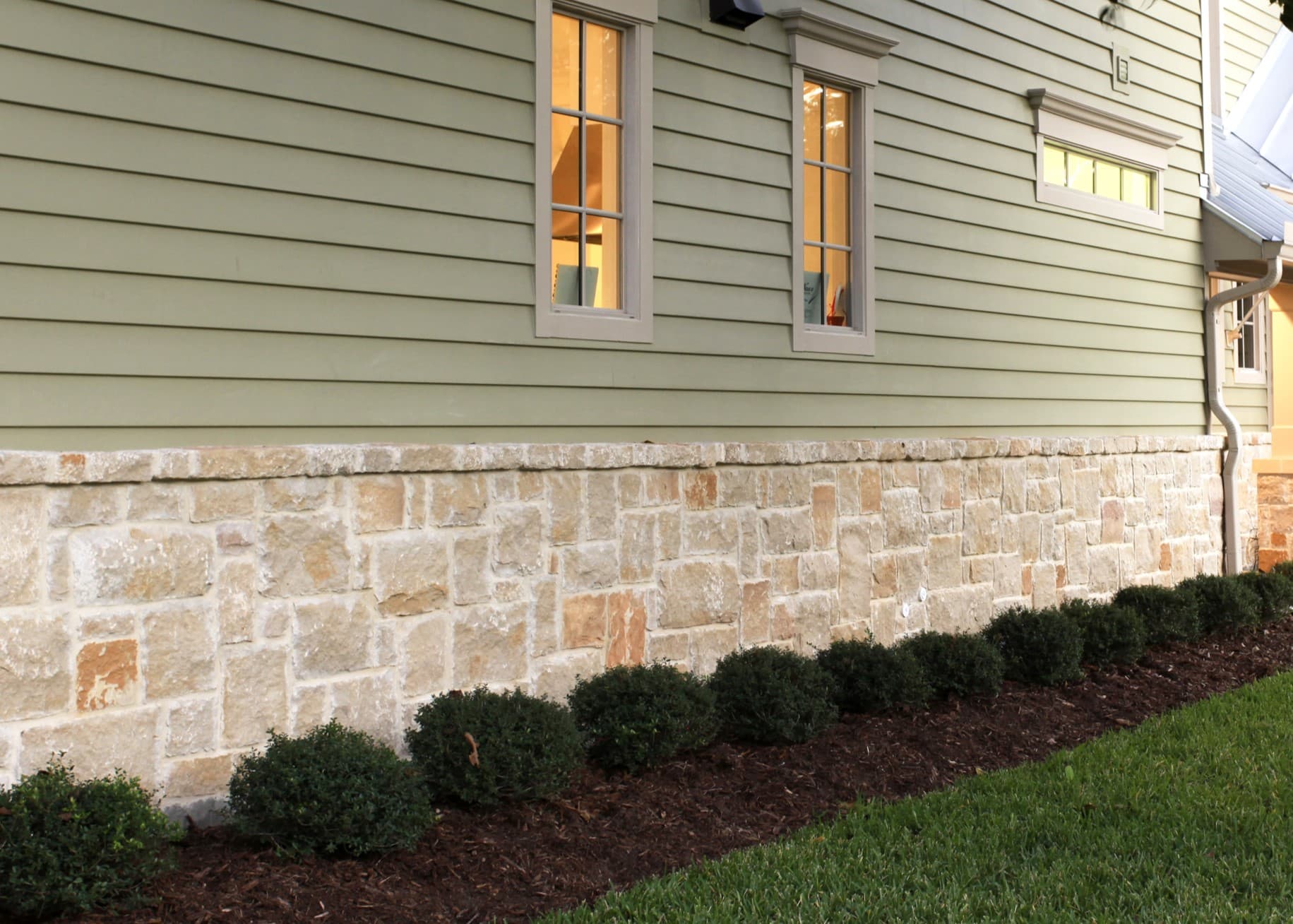 Prepare Your Home for Winter: CHECK THE FOUNDATION House with Succulent Green Hardie lap siding and stone foundation