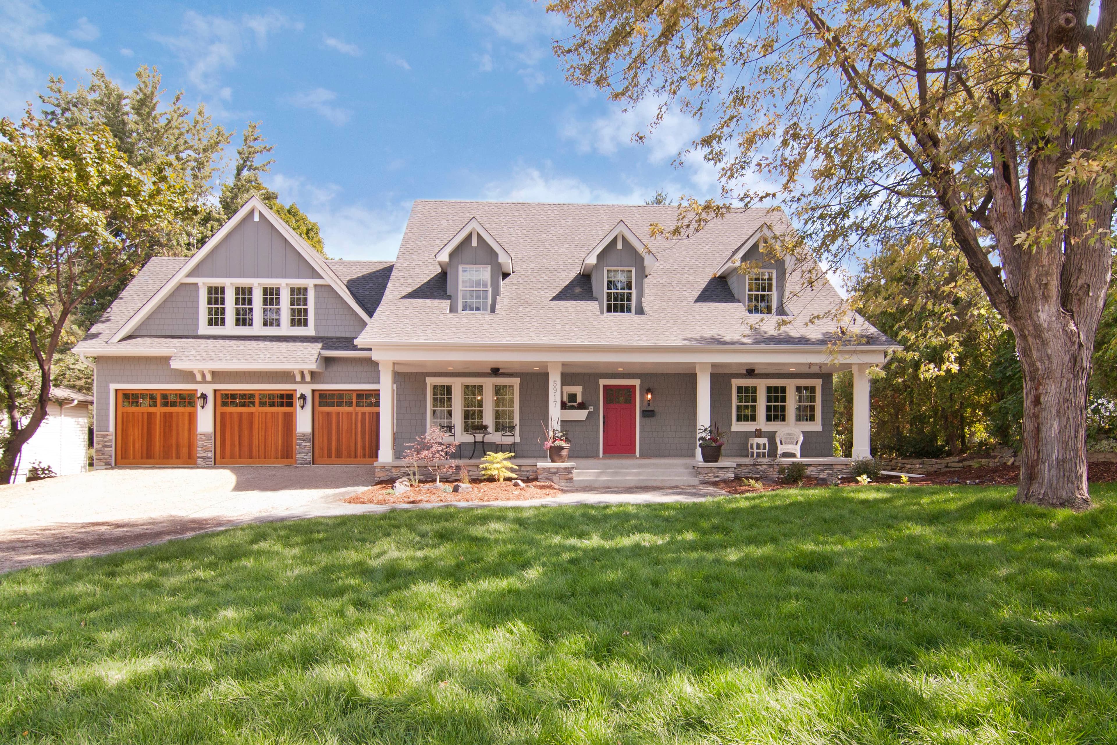 Cape Cod Style - A traditional Cape Cod home with gray plank lap siding and white trim A traditional Cape Cod home with gray plank lap siding and white trim