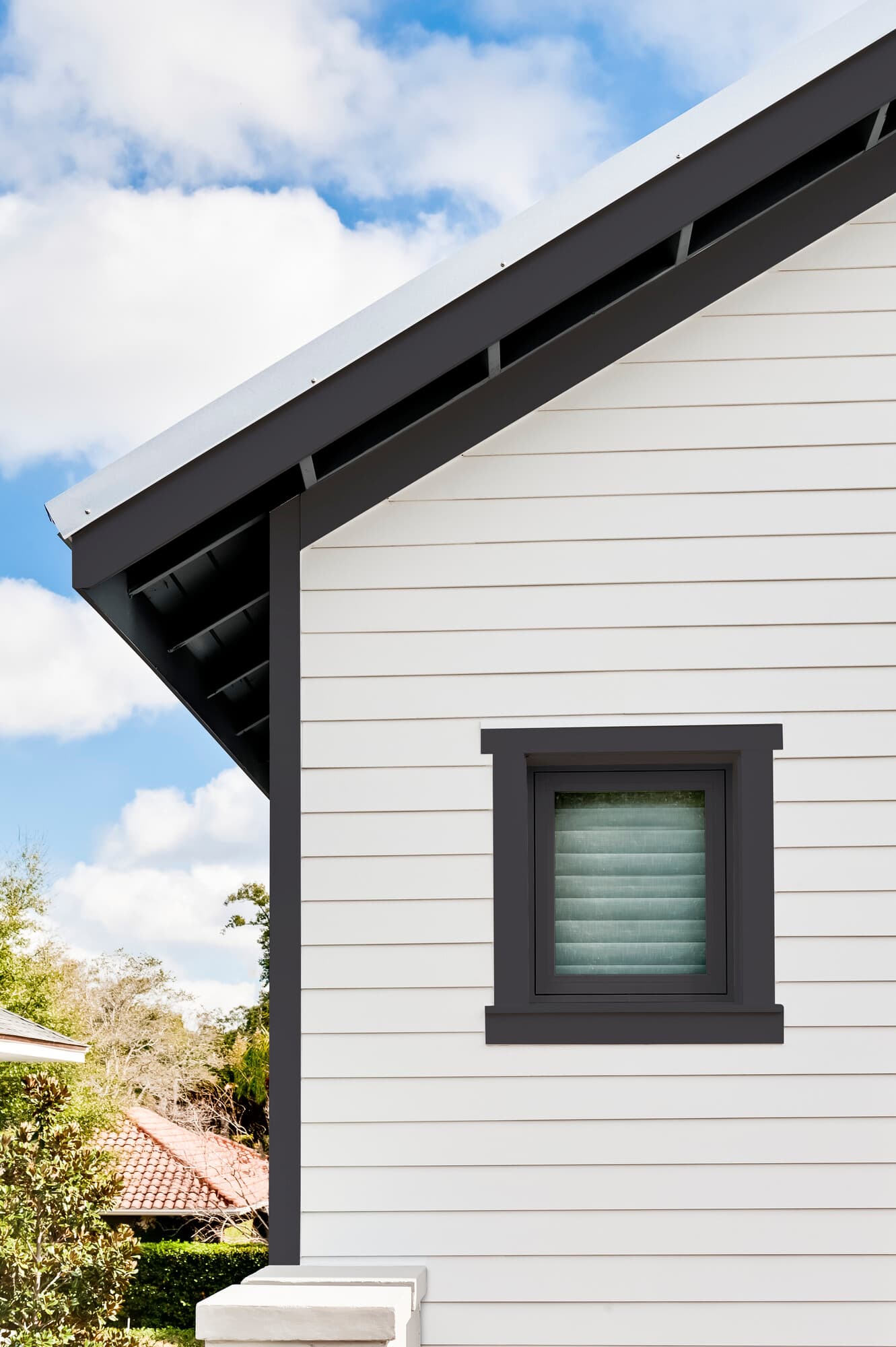Detail of house clad in Evening Blue Hardie plank lap and Arctic White Hardie trim Detail of house clad in Evening Blue Hardie plank lap and Arctic White Hardie trim